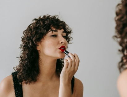 Žena u ogledalu nanosi crveni ruž