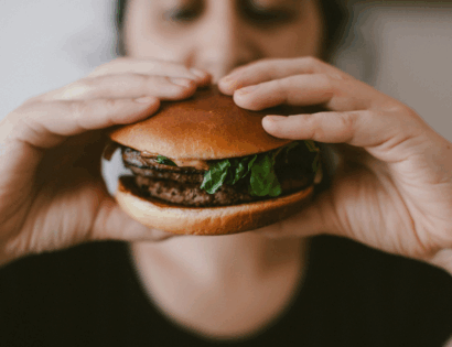 Žena drži hamburger u rukama