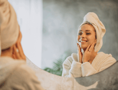 Žena promatra zdravu kožu u ogledalu nakon ZO Skin Red Carpet Peel tretmana