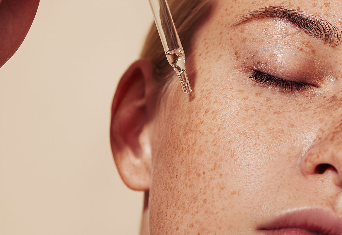 Primjena seruma za lice pomoću kapaljke na kožu lica